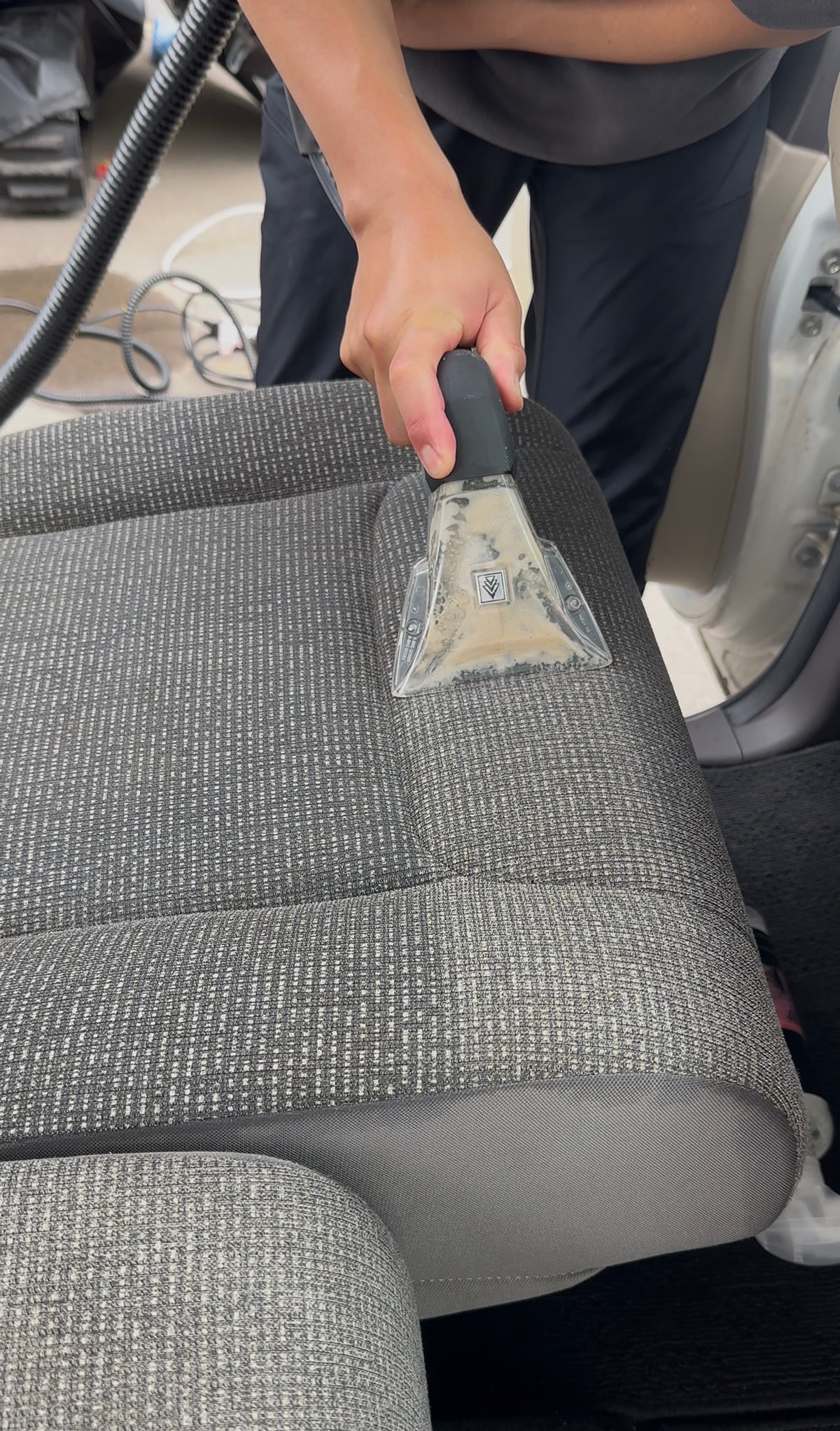 車内シートを専用機材で清掃する施工風景